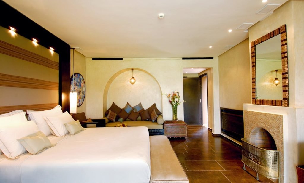 Elegant hotel room featuring a spacious bed, stylish decor, and warm lighting.